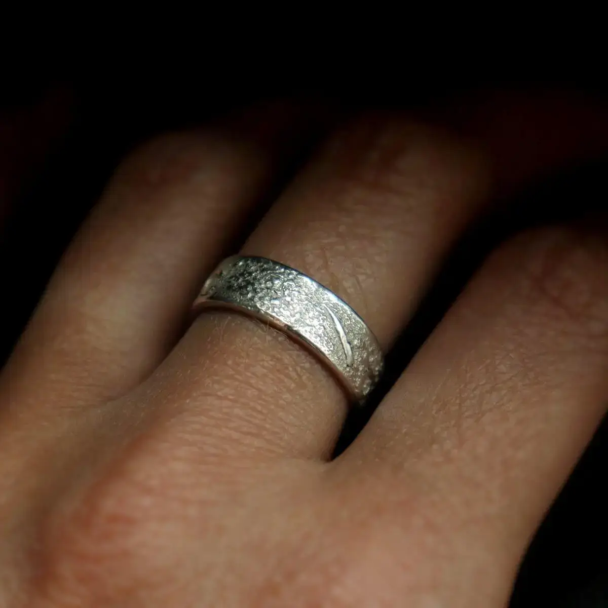 otwarty pierścionek srebrny z fakturą na palcu